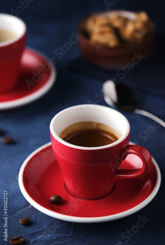 Red Mug of aromatic espresso on a blue table.