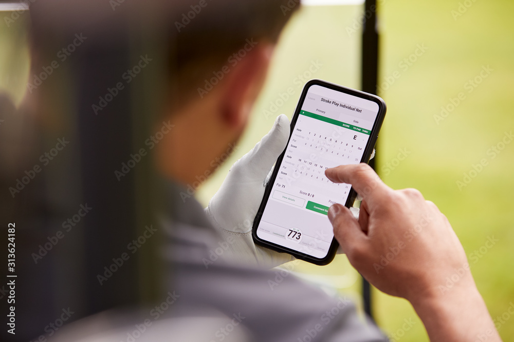Close Up Of Male Golfer In Buggy Checking Score On Mobile Phone App Close Up Of Male Golfer In Buggy Checking Score On Mobile Phone App