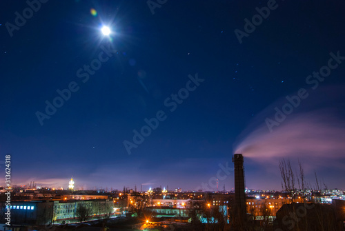 night city landscape, with a central chimney. Smoke pollution concept long exposure moon landscape
