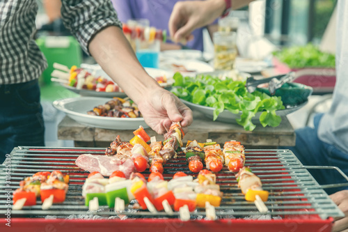 Wallpaper Mural A man grilling pork and barbecue in dinner party. Food, people and family time concept. Torontodigital.ca