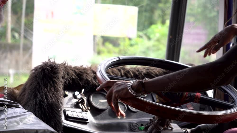 A driver drives a bus in Asia. Close-up of the steering wheel and hands.