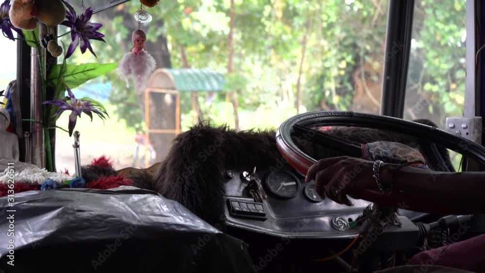 A driver drives a bus in Asia. Close-up of the steering wheel and hands.