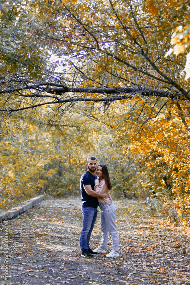 Young couple in love hugging in the Park. Man and woman alone with each other. Warm autumn evening in the forest. Young couple in love hugging in the Park. Man and woman alone with each other. Warm autumn evening in the forest.