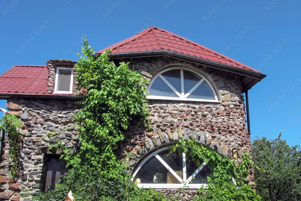  Russia, the city of Rostov-on-Don, May 2019.Fabulous house of stones on a background of blue sky. Summer house home-made in a summer cottage.                 