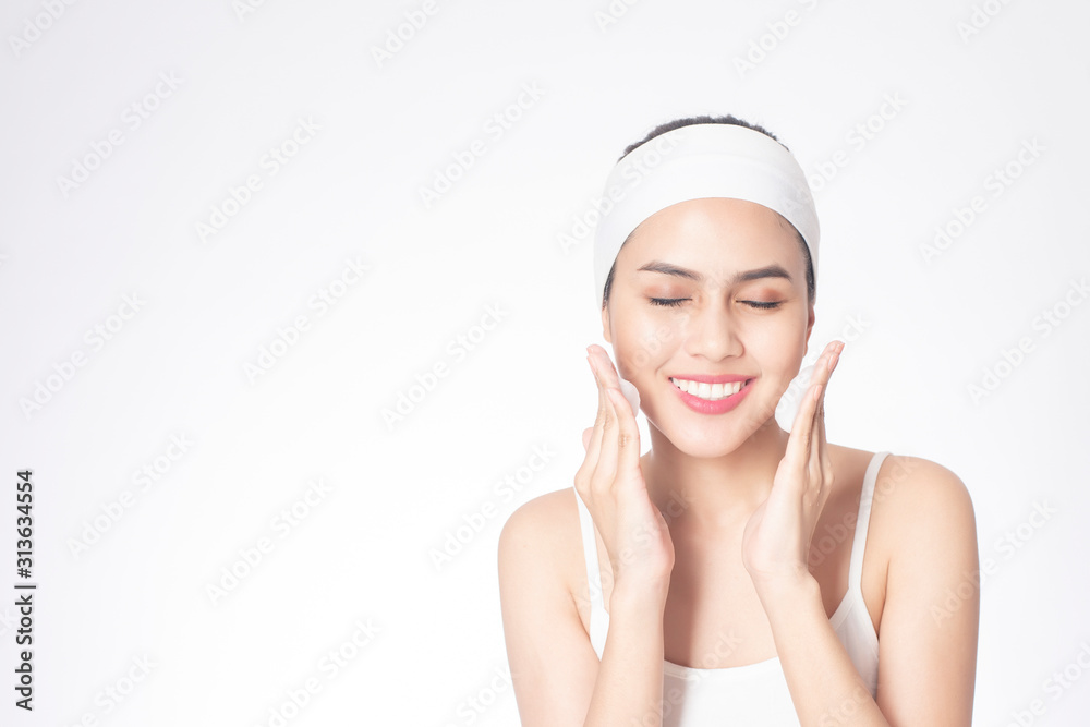 Beautiful woman is washing her face on white background Beautiful woman is washing her face on white background
