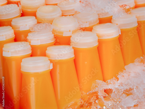 Fresh carrot juice or orange juice, packed in a ready-to-drink frozen plastic bottle for sale.