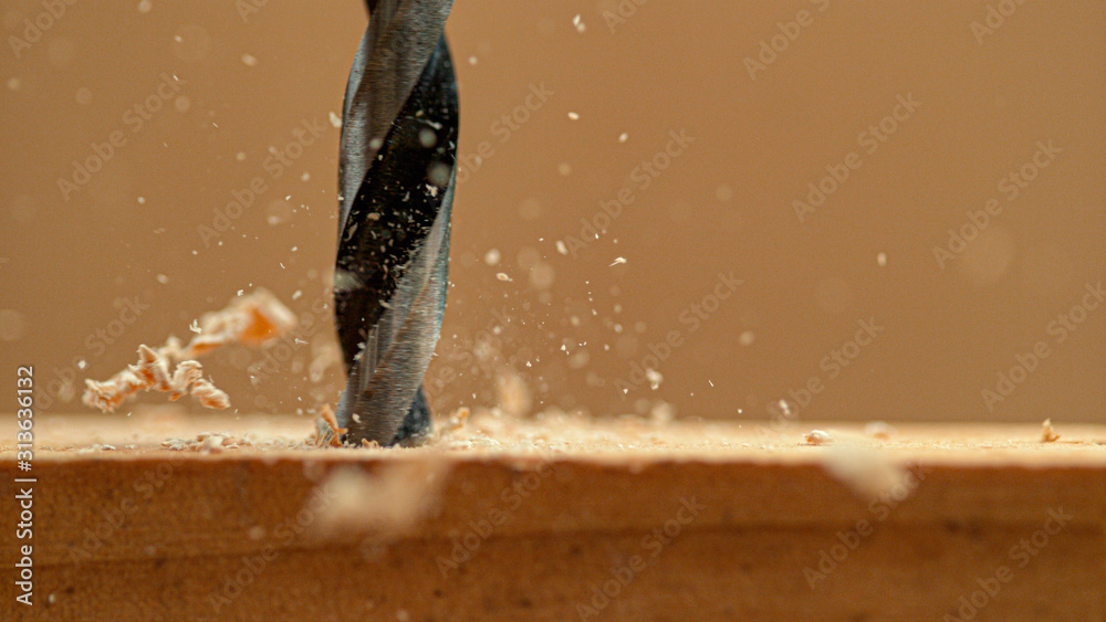 MACRO: Wood chips fly off a plank as handyman drills holes into the workpiece. - obrazy, fototapety, plakaty 