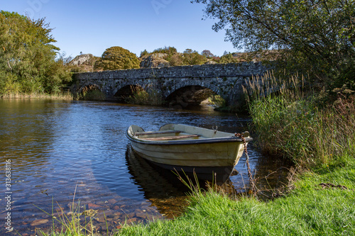 Boat on the river near stone bridge  Pont Pen-y-llyn  North Wales