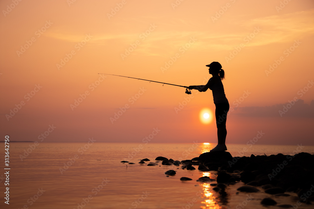 Woman fishing on Fishing rod spinning in Norway. Stock Photo
