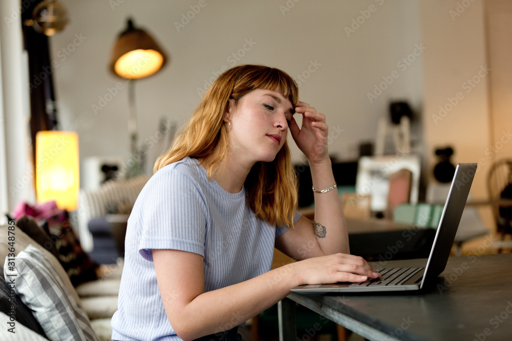 Portrait of pensive young woman sitting in a coffee shop using laptop Portrait of pensive young woman sitting in a coffee shop using laptop
