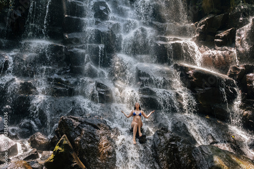 Young woman near Kanto Lampo waterfall, Bali, Indonesia photo