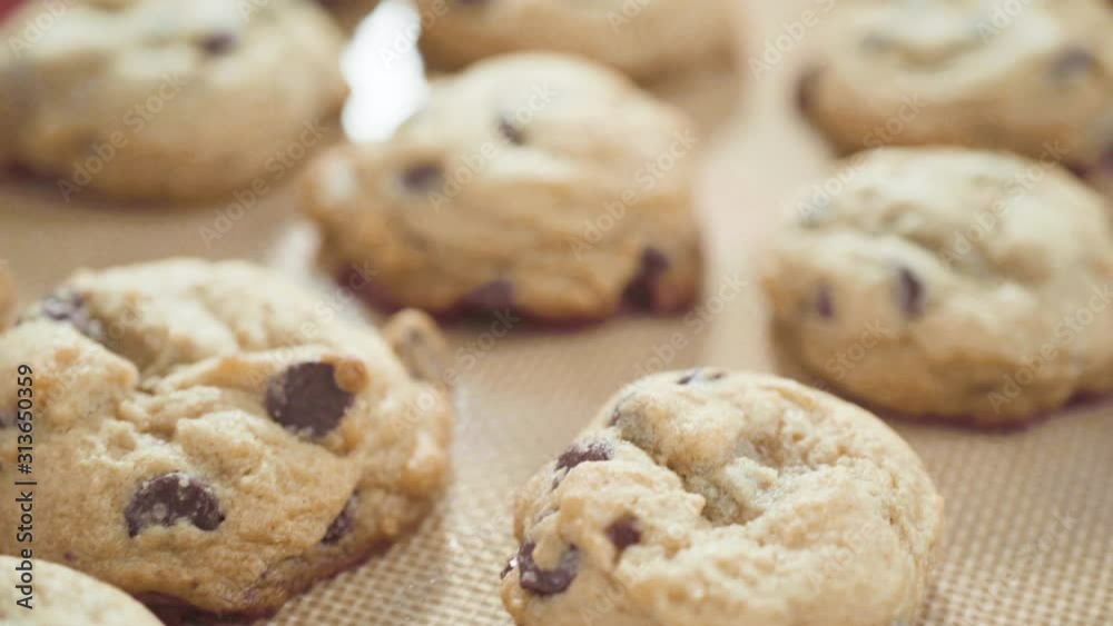 Step by step. Scooping homemade chocolate chip cookies with metal dough scoop to the baking sheet.