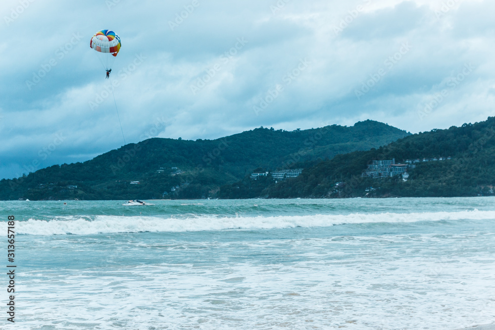 Thailand - July, 2019: skydiver flies through the sky over the sea Kata beach Thailand - July, 2019: skydiver flies through the sky over the sea Kata beach