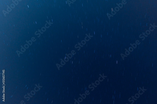 View to the moving stars at night, dark blue sky background. Long exposure shot. 