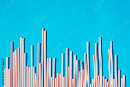 Plastic cocktail straws arranged in columns of statistics graph on a blue background
