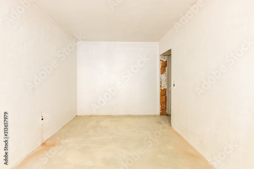 New empty room under construction. Plaster walls. New home. Concrete walls. Interior renovation.