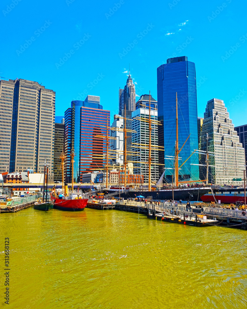 Ship at Pier 17 and harbour of South Street Seaport with Skyline of Skyscrapers in Manhattan, New York City, America USA. American architecture building. Metropolis NYC. Cityscape. Hudson, East River