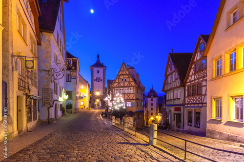 Decorated and illuminated Christmas street with gate and tower Plonlein in medieval Old Town of Rothenburg ob der Tauber  Bavaria  southern Germany