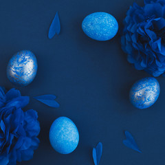 Blue easter eggs ombre and paper flowers on dark background. Easter stylish minimal composition. Top view, flat lay, copy space