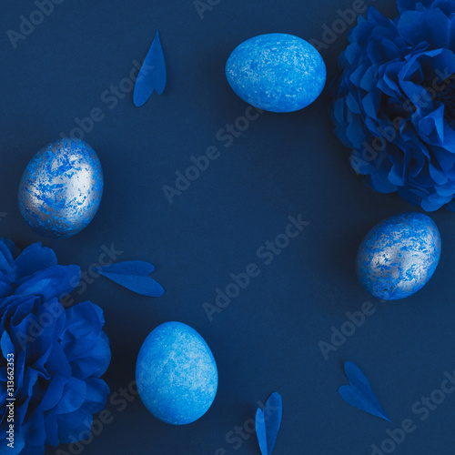 Blue easter eggs ombre and paper flowers on dark background. Easter stylish minimal composition. Top view, flat lay, copy space