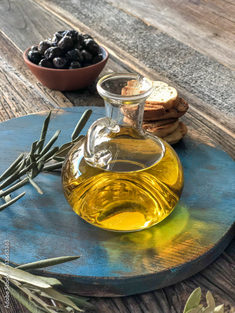 bottle of olive oil and olives on a wooden table bottle of olive oil and olives on a wooden table