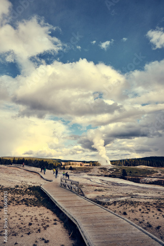 A wooden pathway makes it's way through mud pots toward old faithful