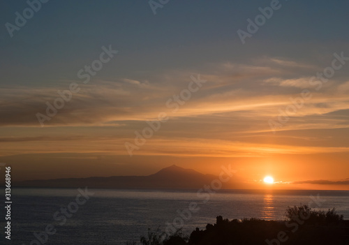 Beautiful orange sunrise over calm ocean and mountain pico del Teide at Tenerife seen from La Palma, Canary Island
