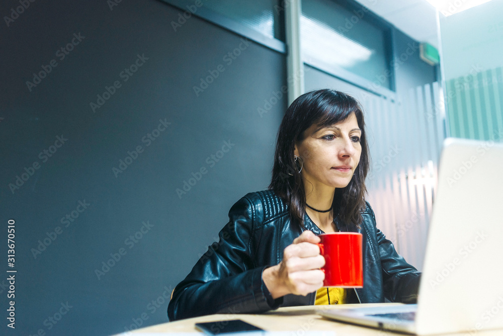 Young woman is drinking hot beverage at workplace. Young woman is drinking hot beverage at workplace.