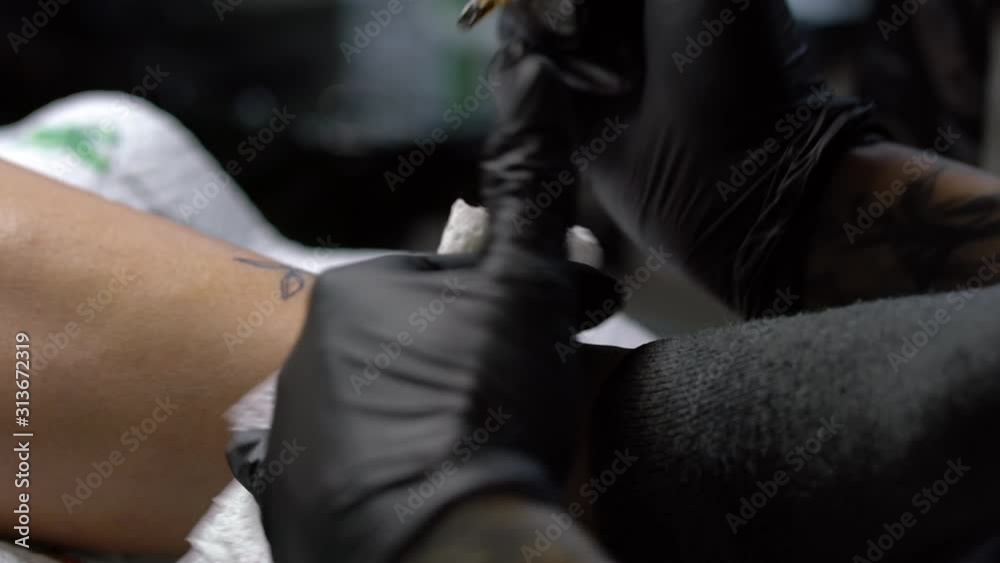 Tattoo female artist makes a tattoo on a female leg. Tattoo female artist makes a tattoo on a female leg.