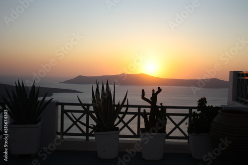 View of the island of Nea Kameni, the sea and the caldera of Santorini at sunset