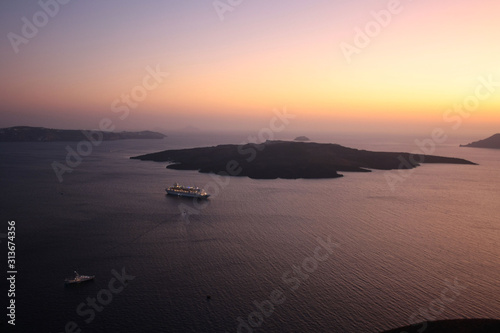 View of the island of Nea Kameni, the sea and the caldera of Santorini at sunset