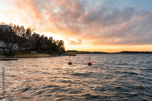 Colorful clouds. Sunset landscape background. Silhouettes of islands with pines. Stockholm Archipelago. Scandinavia. Seaside. Horizon line  skyline with beautiful clouds in the rays of the setting sun