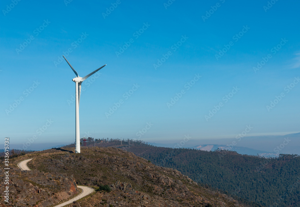 Wind Turbines at Baloiço da Boneca in Portugal Mountain region with mist blue sky in the background