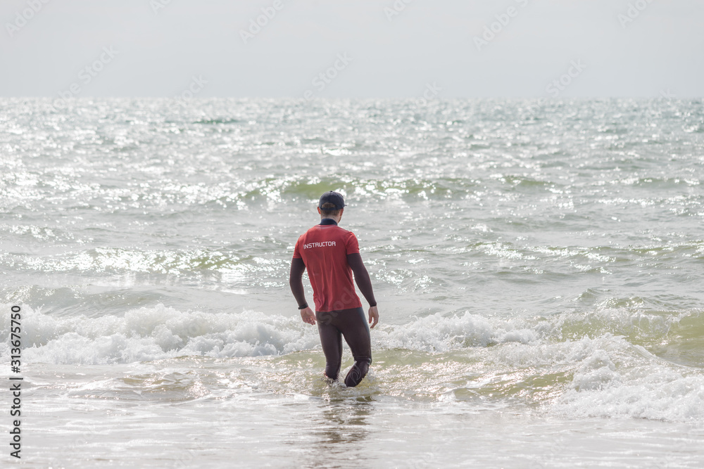 surf instructor performs a surf check before his first class. surf instructor performs a surf check before his first class.