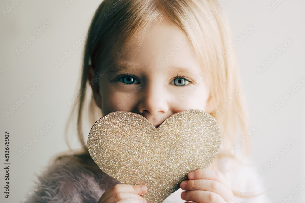 Valentines day. Little girl with a heart. Portrait of a little girl holding valentine's card. - obrazy, fototapety, plakaty 