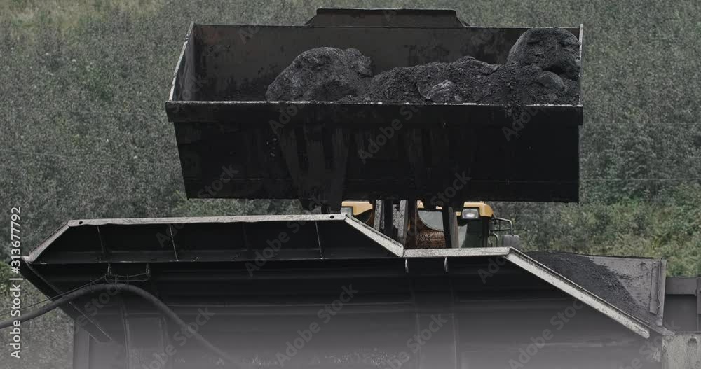 Slow motion loading of an excavator into mining truck. Excavator loading coal in big dump trucks. Loading coal into sorting plant. Loading of coal truck using excavator slow motion Slow motion loading of an excavator into mining truck. Excavator loading coal in big dump trucks. Loading coal into sorting plant. Loading of coal truck using excavator slow motion