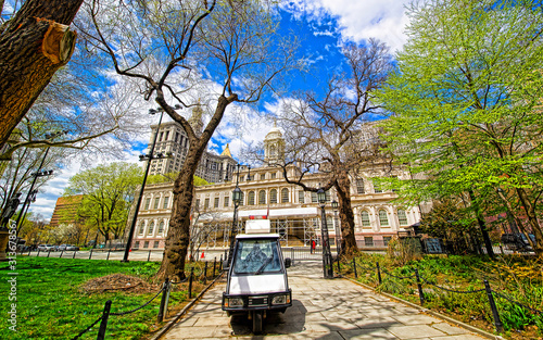 Magnolia Trees in Blossom at City Hall Park in Lower Manhattan, New York, USA. View with Skyline of Skyscrapers architecture in NYC. Nature background. Urban cityscape. NY, US photo