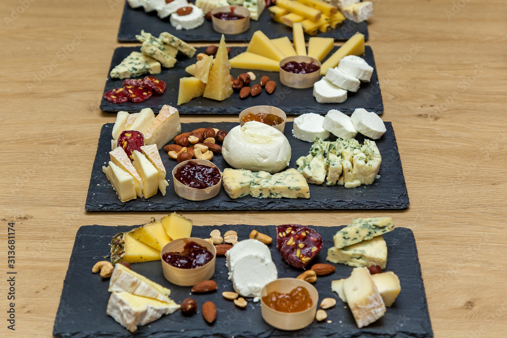 Cheese plates with cutting cheese on dark boards