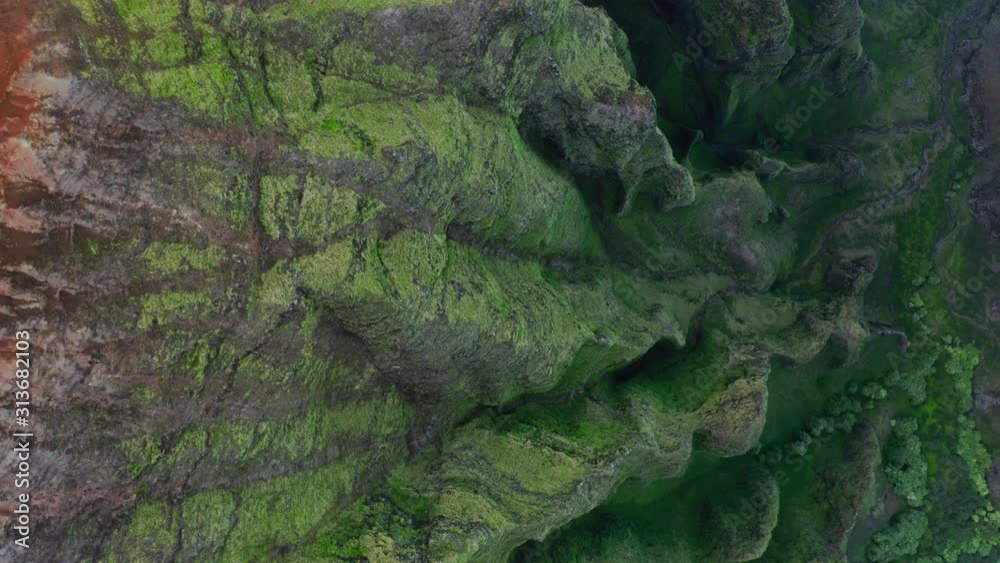 Top view over the steeply sloping wavy rocky ridges of Hawaiian mountainous formations. Tropical exotic relief of the island is on the shot. Vibrant greenery cover the surface of the cliffs. Aerial,4K Top view over the steeply sloping wavy rocky ridges of Hawaiian mountainous formations. Tropical exotic relief of the island is on the shot. Vibrant greenery cover the surface of the cliffs. Aerial,4K