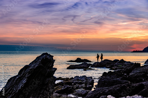 Couple on rocks fishing in the sea