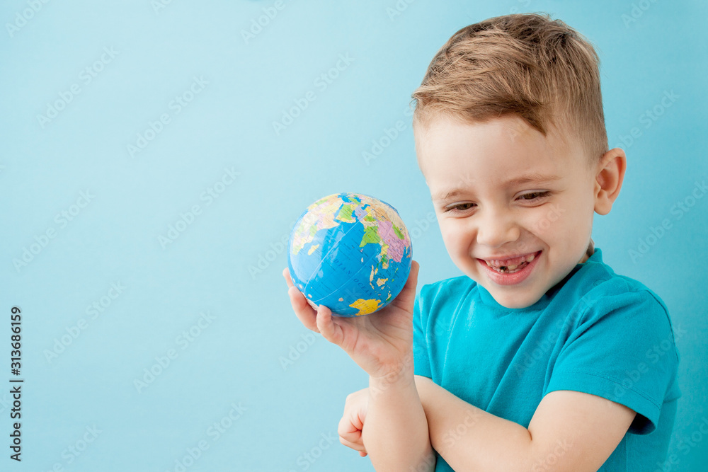 Little boy holding a globe on blue background Little boy holding a globe on blue background