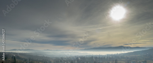 Fog in mountains before sunrise, mountain valley with clouds. View to mountains of the Carpathians