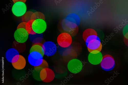 Christmas tree with defocused lights and star. Christmas abstract blur background. Out of focus holiday background with christmas tree. 