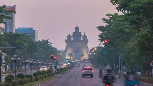 Vientiane Laos time lapse 4K, city skyline night to day sunrise timelapse at Patuxai (Patuxay) and Lane Xang street photo