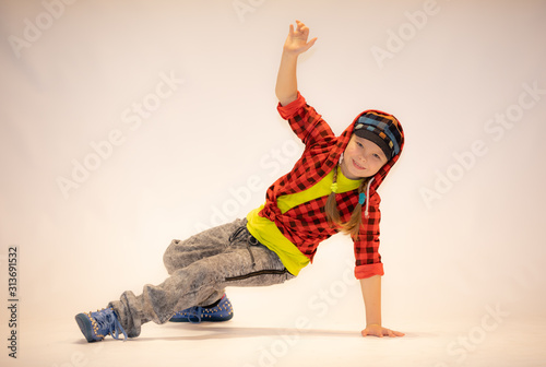 Fotografie a little girl performs breakdance, a child in a unique acrobatic dance pose,bgir