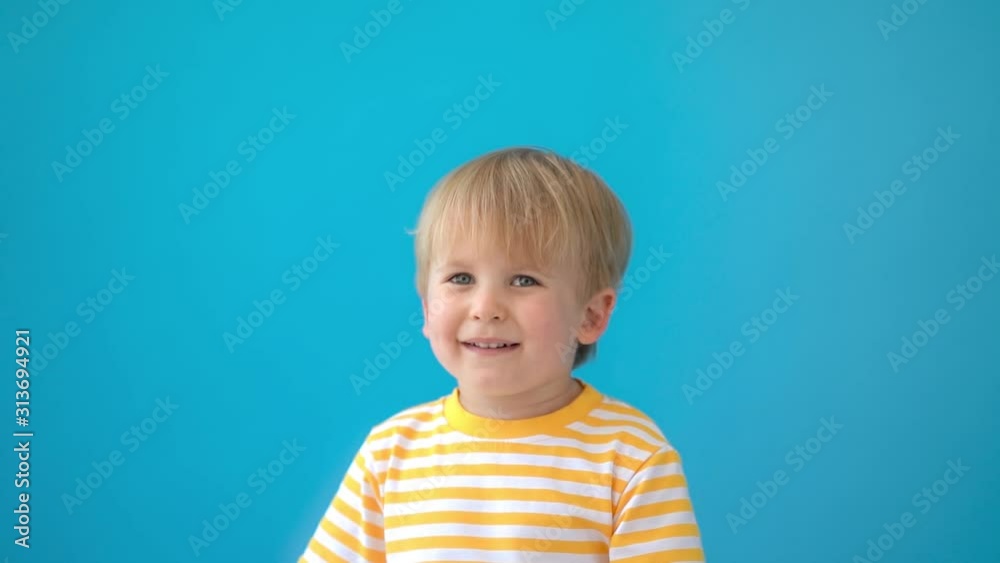 Happy child laughing against blue background. Slow motion Happy child laughing against blue background. Slow motion