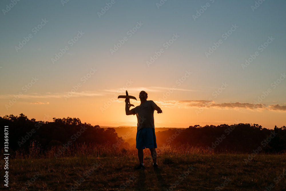 Fototapeta premium man with airplane at sunset