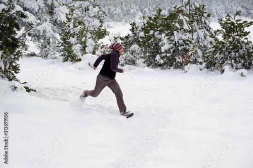 scared young man running away in snowy forest