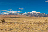 Looking across the Plains at Sand Dunes and Snowy Mountains