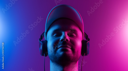 A man with closed eyes enjoys music. Dual color theme photo